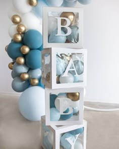 blue and white balloons are in front of a balloon wall that says b is for baby