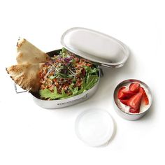 a lunch box with salad, pita bread and strawberries