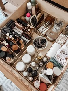 a drawer filled with lots of different types of makeup and other items on top of it