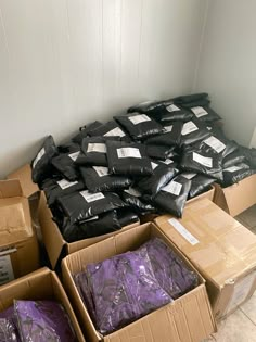 several boxes are stacked on top of each other with purple bags in front of them