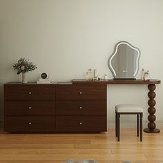 a bedroom with a dresser, mirror and stool