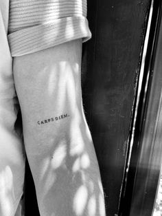 a woman's arm with the word carppiism tattooed on it, in black and white