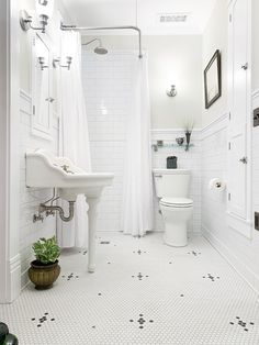 a white bathroom with black and white floor tiles