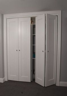 two white closets in the corner of a room next to a wall and carpeted floor