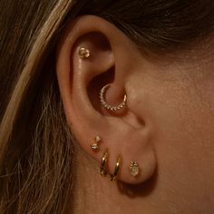 a close up of a person's ear with three different types of piercings