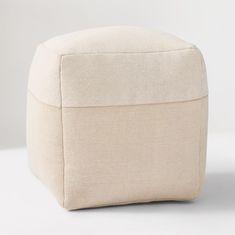 a white ottoman sitting on top of a white floor