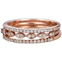 two rose gold wedding bands with diamonds on each band and one diamond set in the middle