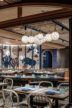 a restaurant with blue walls and wooden tables in the center is decorated with elephant designs