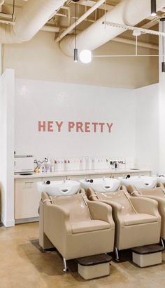 there are many chairs in the room with signs on the wall behind them that say hey pretty