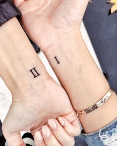 two people holding hands with tattoos on their wrists and the words i love you written on them