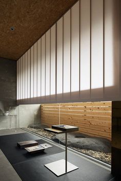 an empty room with wooden slats on the wall and black carpeted flooring