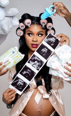 a pregnant woman is holding up her hair rollers