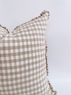 a brown and white checkered pillow with ruffled edges