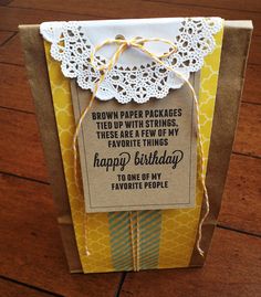 a brown paper package sitting on top of a wooden floor next to a yellow bag