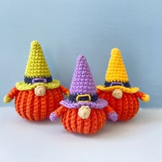 three crocheted pumpkins with witches hats on them sitting next to each other