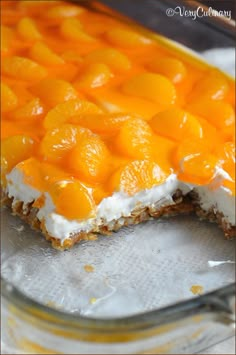 an orange dessert with white frosting in a glass dish