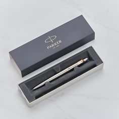 a pen in a gift box on a white marble countertop with the packaging open