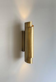 a wall mounted light on the side of a white wall