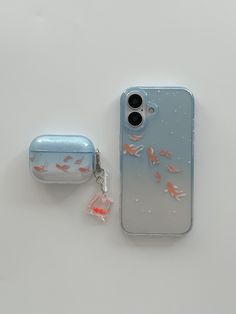 an iphone case with fish on it next to a keychain