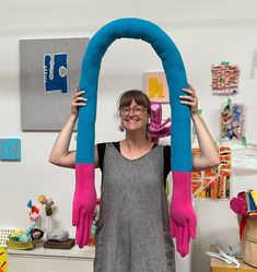 a woman holding up a giant blue and pink object