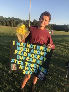 a young man holding a sign that says i may not know much about field hockey but came stuck together at hoco