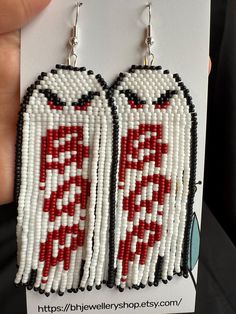 a pair of red and white beaded coca cola bottle earrings on a card for sale