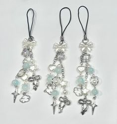 three different types of earrings with charms on each one side and dangling from the back