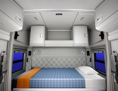 the interior of a vehicle with blue carpet and white walls, windows, and bed