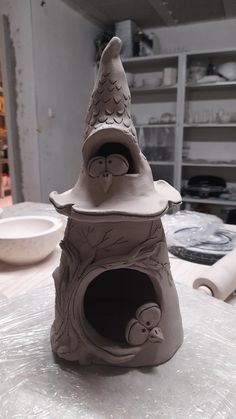 a clay sculpture of a birdhouse on a table