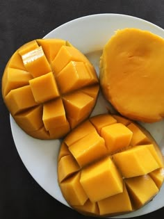 three pieces of mango sitting on top of a white plate