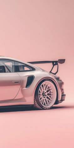 a white sports car parked in front of a pink wall