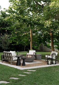 a fire pit surrounded by chairs and tables