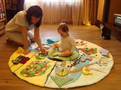 a woman is playing with a baby on the floor