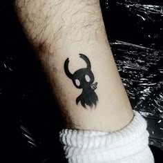 a small tattoo on the ankle of a person with a skull and crossbones