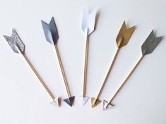 five different types of wooden arrows on a white surface