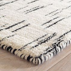 a black and white rug on top of a wooden floor