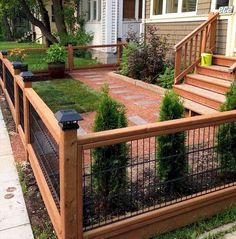 a fenced in yard with some plants on the side and steps leading up to it