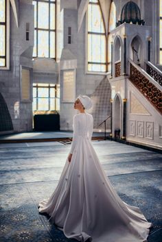 a woman in a white wedding dress standing on the floor