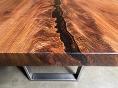 a close up of a wooden table with metal legs and an interesting pattern on it