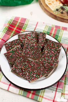 a white plate topped with chocolate and sprinkles next to other dessert items