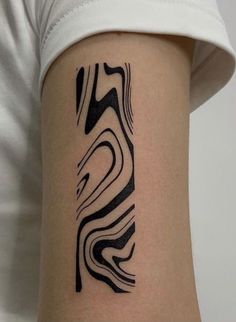 a woman's arm with a black and white tattoo design on the left side of her arm