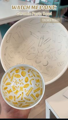 a hand holding a bowl with drawings on it and the words ceramic pasta bowl painted in yellow