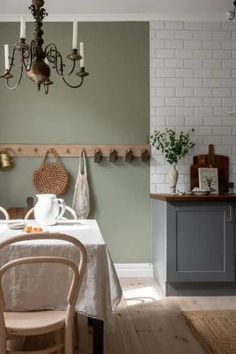 a dining room with a table and chairs in front of a wall mounted pot rack