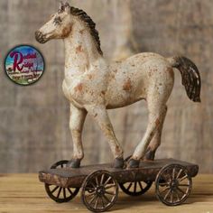 an old fashioned toy horse is sitting on a wooden wheelbarrow with the words vintage horse on wheels below it