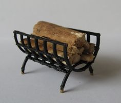 a small piece of wood sitting on top of a metal rack filled with firewood