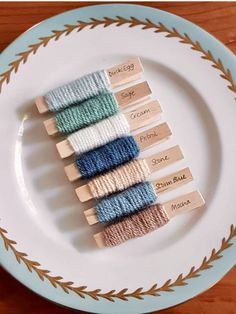 four spools of thread sitting on top of a white plate