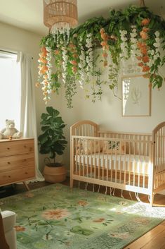 a baby's room with a crib and flowers hanging from the ceiling above it