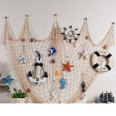 there is a net hanging on the wall with various items attached to it, including an anchor and life preserver