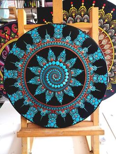 three black and blue plates sitting on top of a wooden easel