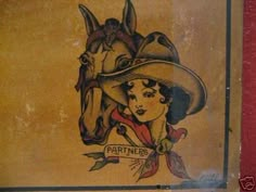 an old book with a drawing of a woman wearing a cowboy hat and holding a horse's head